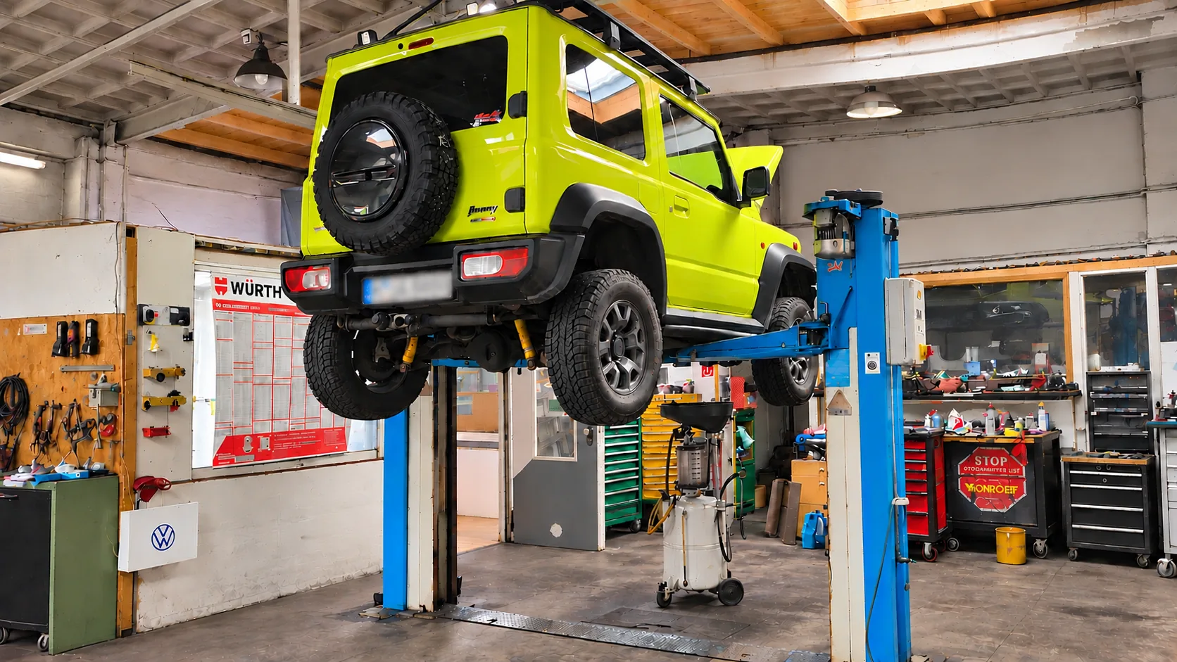Suzuki Jimny auf der Hebebühne beim Ölwechsel – Altöl wird über das Ölauffanggerät abgelassen, DENKO Kfz-Werkstatt in Hemmingen